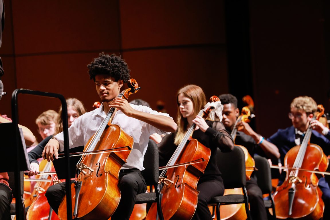 An orchestra performs onstage.